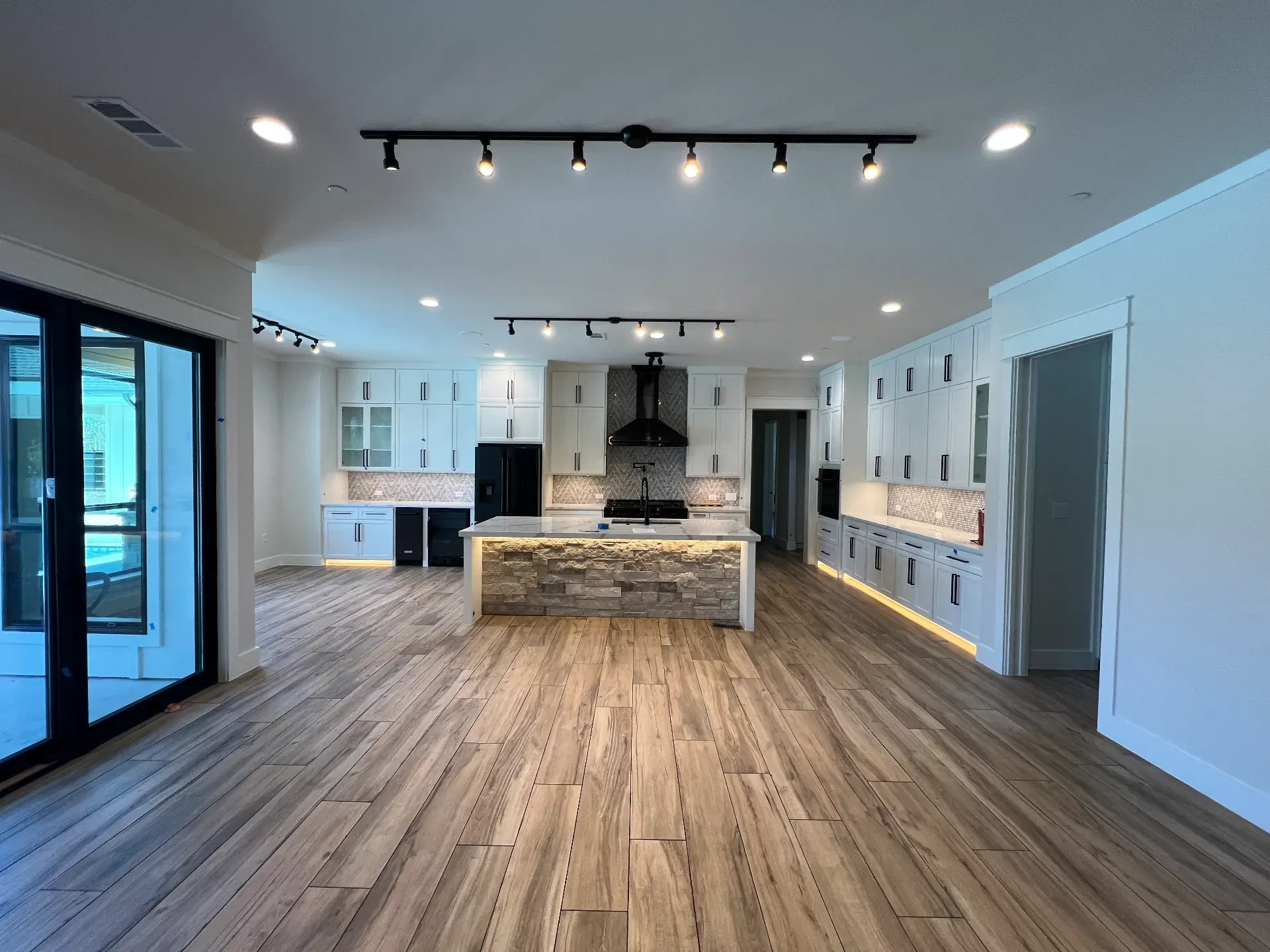 New home kitchen built by Venado Construction with white cabinetry and a full-height stone island